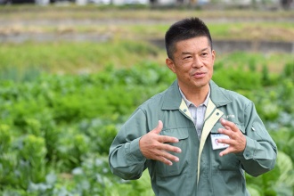 「あがらの畑」を背に語る、JA紀の里 営農部 下田和敬二部長(写真=水野浩志)