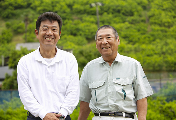 広大なレモン畑を背景に。JA広島ゆたかでは、これからも生産者と二人三脚でレモンの増産に取り組んでいく