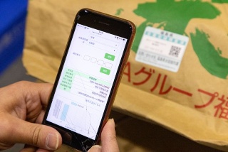 実際に貼付されたQRコードと、スマートフォンで読み取る様子