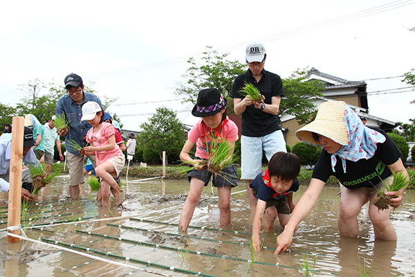 泥だらけになりながらの田植え。初めての体験に子どもたちは大騒ぎ<br>（写真：あきんどスシロー）