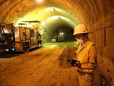 明るい照明が施されたトンネル坑内で無線LAN電波の飛距離を調べる佐藤氏