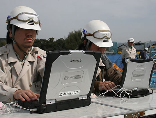 園田高架橋上り線の現場で、タフブックを使って緊張管理を行う清水建設・川田建設JV工事係の池田勝平氏（左）と奥山昌和氏（右）。