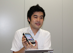 パナソニック システムネットワークス株式会社 ターミナルシステムビジネスユニット 商品開発室　参事 二文字屋 剛 氏   2001年入社。以来、パナソニックの携帯電話、スマートフォン「ELUGA」の開発を長年に渡り担当。2013年からタフパッドの開発に加わり、「タフパッドFZ-E1/X1」を世に送り出す。この機種にかける情熱と抜群の説明能力の高さから、開発者でありながら技術営業も兼ね、「タフパッドのプレゼンの名手」としてその名を知られるようになっている。